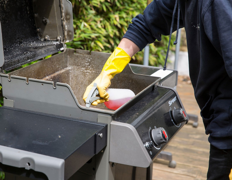 Cleaner spraying BBQ grill