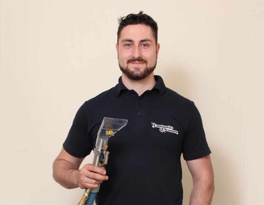Upholstery professional holding a vaccuum cleaner