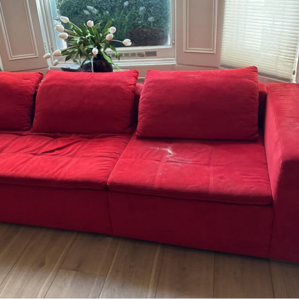 Red sofa before professional upholstery cleaning