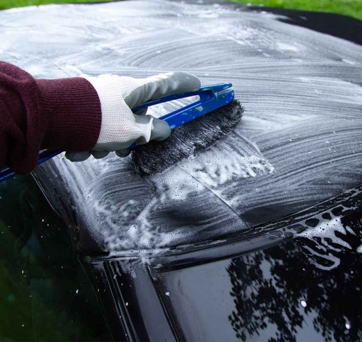 Close up on a car care specialist cleaning a soft top convertible