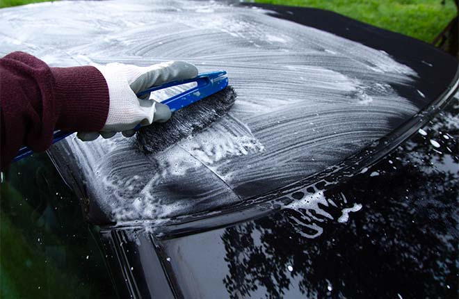 Close up on a car care specialist cleaning a soft top convertible