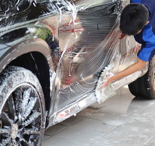 Car cleaning specialist, performing exterior cleaning by hand