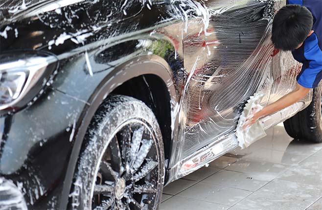 Car cleaning specialist, performing exterior cleaning by hand